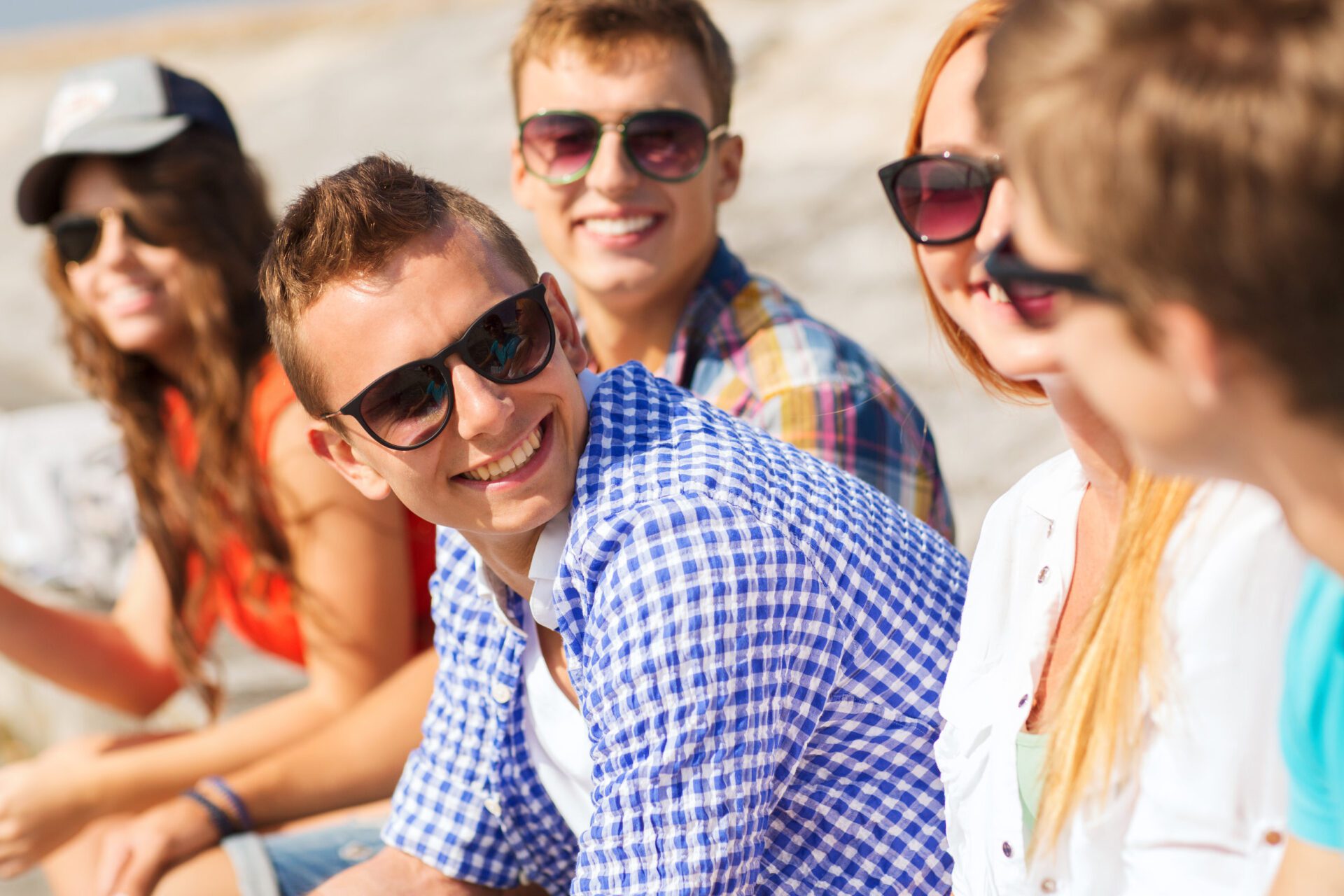 close up of smiling friends sitting on city street